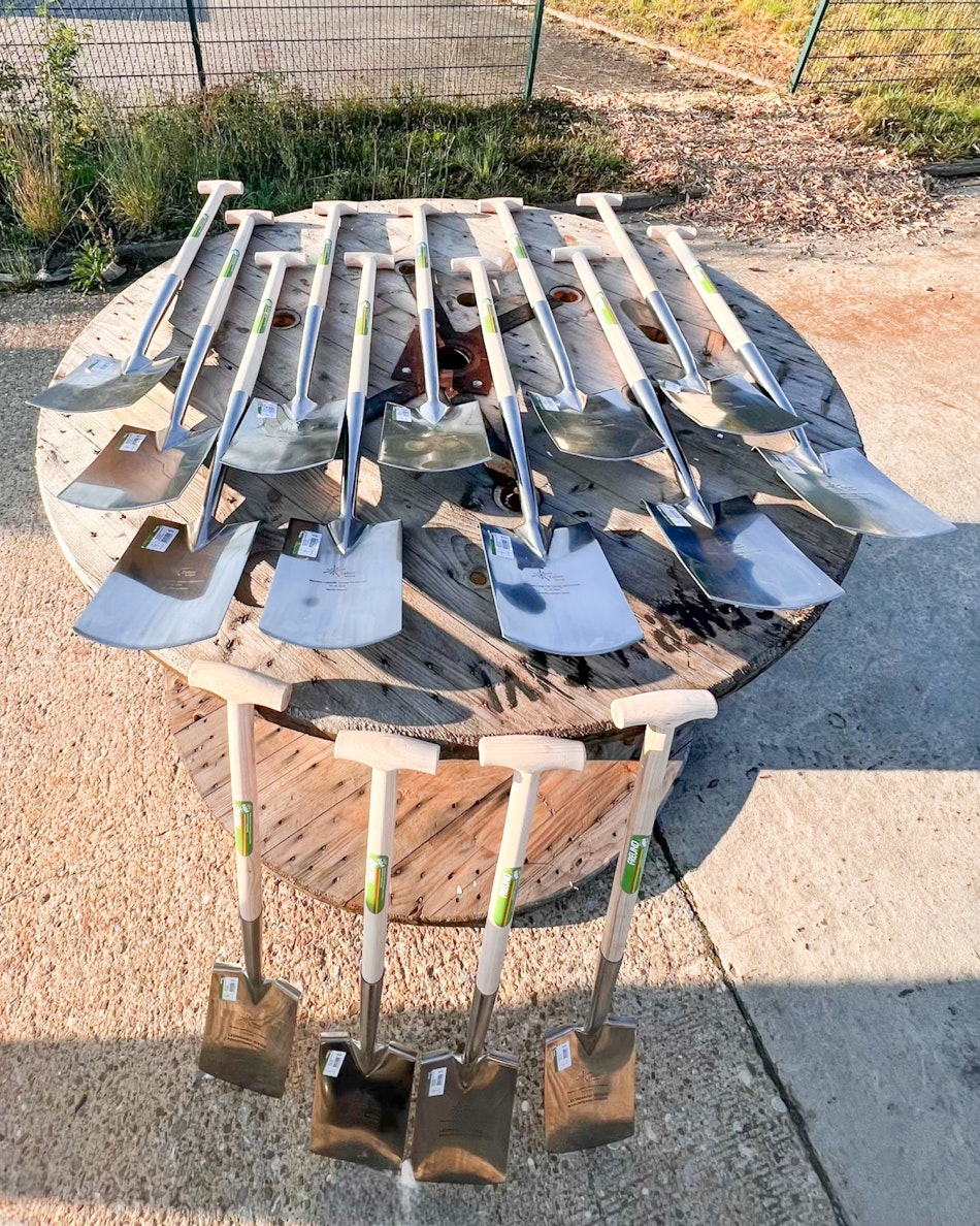 mehrere Spaten liegen auf einer Leertrommel aus Holz