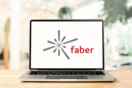 Aufgeklappter Laptop auf Holztisch mit Faber-Logo auf Display