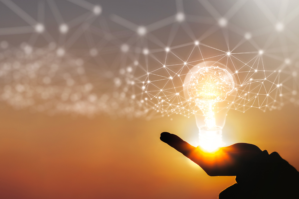 Photo Innovation Hand with illuminated light bulb, symbolising innovation.