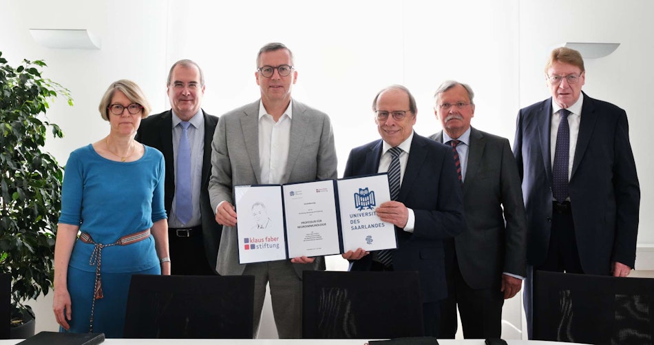 Gruppen von Menschen, welche einen unterzeichneten Vertrag in die Kamera halten