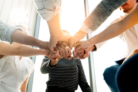 Nahaufnahme von Geschäftsleuten, die ihre Fäuste als Zeichen des Teamworks zusammen sammeln
